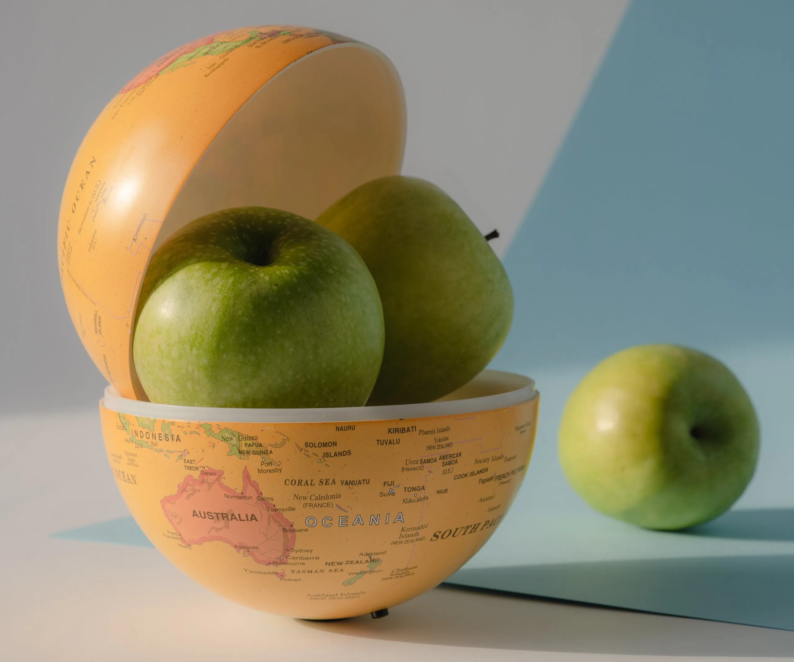 Globe container opened up with 2 apples sitting inside